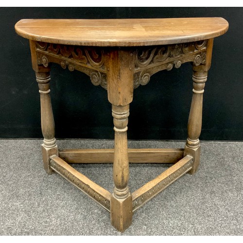 1626 - An 17th century style oak credence table, the Demi-line shaped top, above a carved frieze, three tur... 