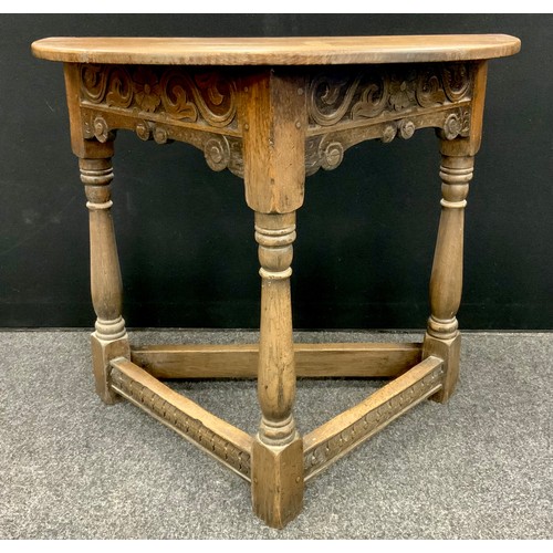 1626 - An 17th century style oak credence table, the Demi-line shaped top, above a carved frieze, three tur... 