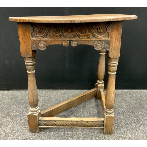 1626 - An 17th century style oak credence table, the Demi-line shaped top, above a carved frieze, three tur... 