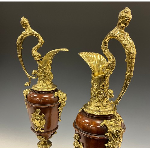 1851 - A pair of Continental gilt metal mounted turned walnut Cellini ewers, in the Renaissance Revival tas... 