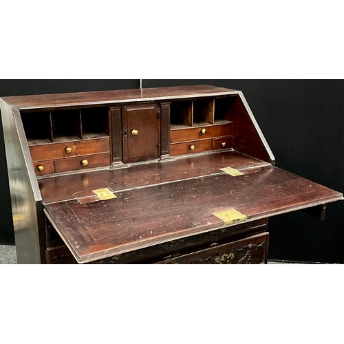 1738 - A George III mahogany bureau, with later neo-classical carved fall door, and drawer fronts, the hing... 