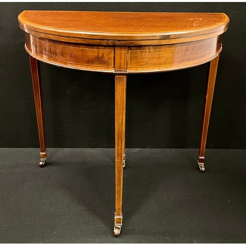 1603 - A George III mahogany Demi-lune shaped card table, the satinwood cross-banded top lifting up and ove... 