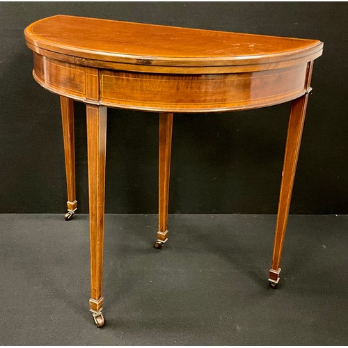 1603 - A George III mahogany Demi-lune shaped card table, the satinwood cross-banded top lifting up and ove... 