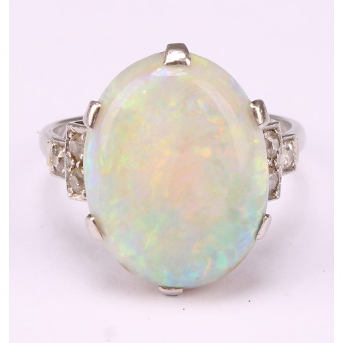 687 - An Art Deco platinum ring, the central large claw set polished opal cabochon, flanked to either side... 