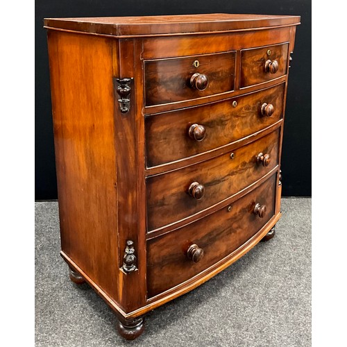 1575 - An early Victorian bow-front chest of drawers, having canted sides, with split-turned finials, turne... 