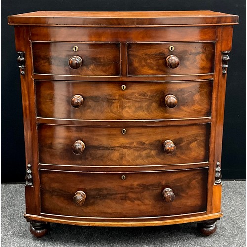 1575 - An early Victorian bow-front chest of drawers, having canted sides, with split-turned finials, turne... 