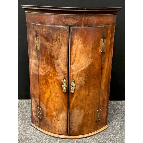 1736 - A George III mahogany bow-front corner cupboard, inlaid shell patera to frieze, above a pair of door... 