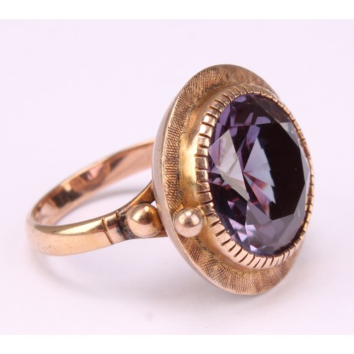 543 - A bespoke 14k rose gold ring, set slightly off centre with a large faceted amethyst, hand engraved b... 