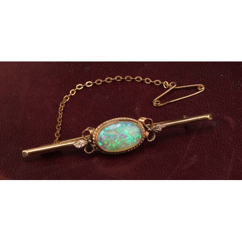 534 - A 9ct gold bar brooch, set with a single polished oval opal cabochon, the stone 14mm, marked 9ct, sa... 