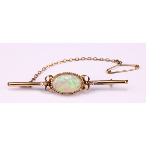 534 - A 9ct gold bar brooch, set with a single polished oval opal cabochon, the stone 14mm, marked 9ct, sa... 