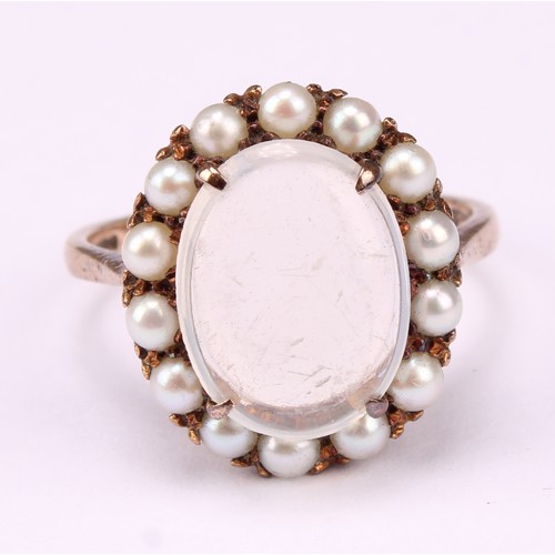 542 - A 9ct rose gold ring, set with a polished oval moonstone cabochon, surrounded by fourteen lustrous s... 