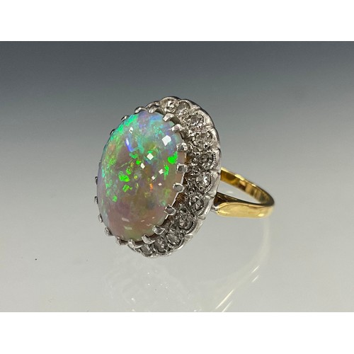 699 - An impressive opal and diamond cluster ring, large oval opal cabochon approx 17mm x 13mm flashing vi... 