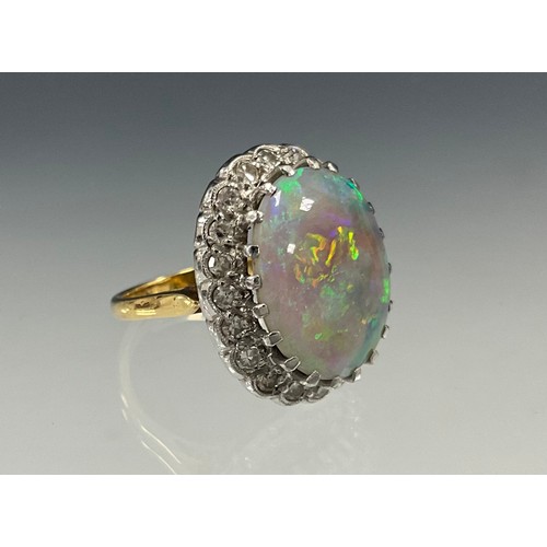 699 - An impressive opal and diamond cluster ring, large oval opal cabochon approx 17mm x 13mm flashing vi... 