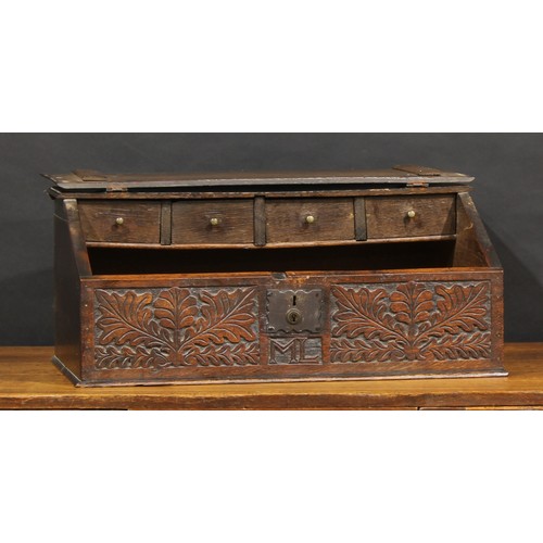 1630 - An 18th century oak boarded table box, hinged sloping cover enclosing four small drawers, the front ... 