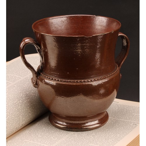 1258 - A brown salt glazed stoneware loving cup, probably Nottingham, loop handles, skirted foot, 18cm high... 