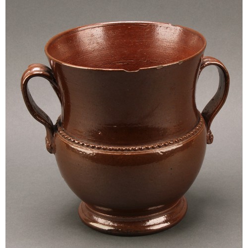 1258 - A brown salt glazed stoneware loving cup, probably Nottingham, loop handles, skirted foot, 18cm high... 