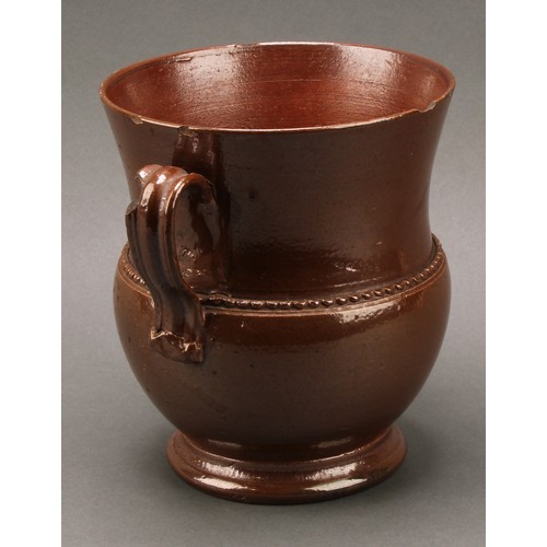 1258 - A brown salt glazed stoneware loving cup, probably Nottingham, loop handles, skirted foot, 18cm high... 