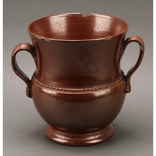 1258 - A brown salt glazed stoneware loving cup, probably Nottingham, loop handles, skirted foot, 18cm high... 