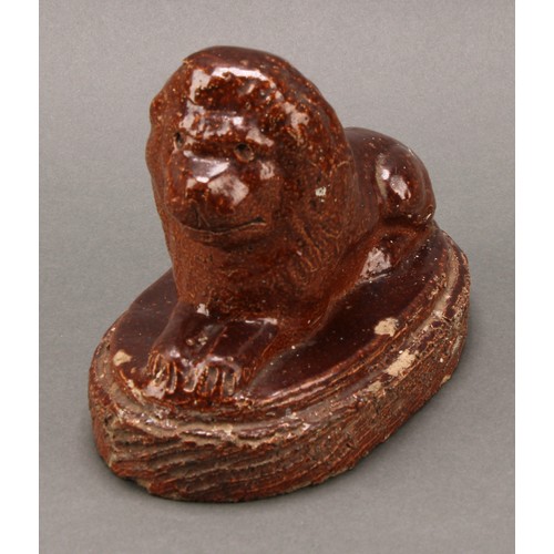 1259 - A 19th century brown salt glazed stone ware model, of a recumbent lion, oval base, 16.5cm wide