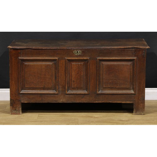 1628 - An 18th century oak blanket chest, hinged top above three raised and fielded panels, stile feet, 65c... 