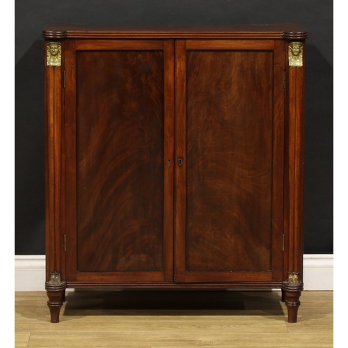 1596 - A 19th century mahogany enclosed pier cabinet or library bookcase, in the Regency Egyptian Revival t... 