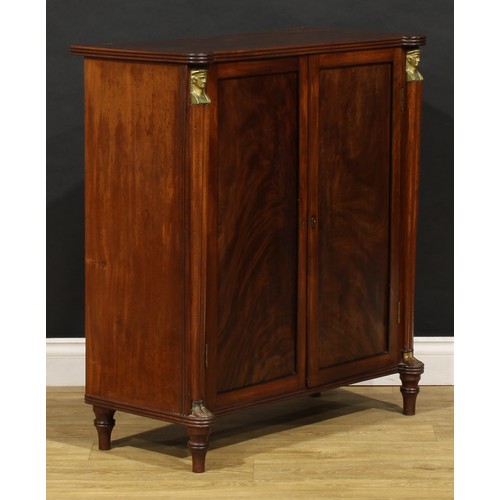 1596 - A 19th century mahogany enclosed pier cabinet or library bookcase, in the Regency Egyptian Revival t... 