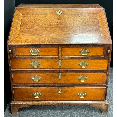 1907 - A Georgian III oak and elm bureau, the fall front enclosing a fully fitted interior, with central ar... 