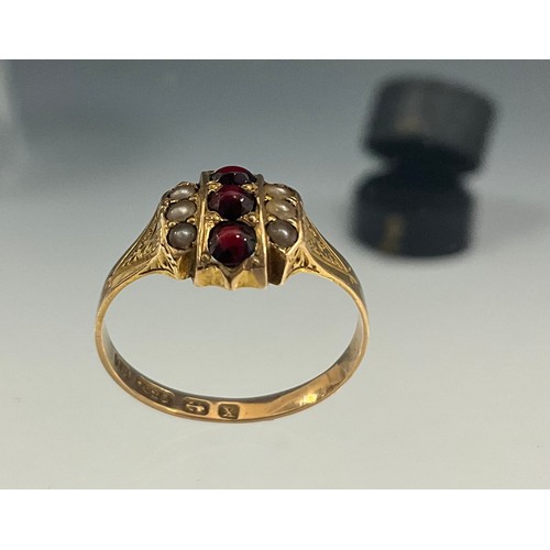 662 - A Victorian garnet and seed pearl ring, set with three red garnet cabochons between three half pearl... 