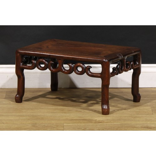 1534 - A Chinese hardwood low kang table, rectangular panelled top, pierced scroll frieze, shaped legs, 28c... 