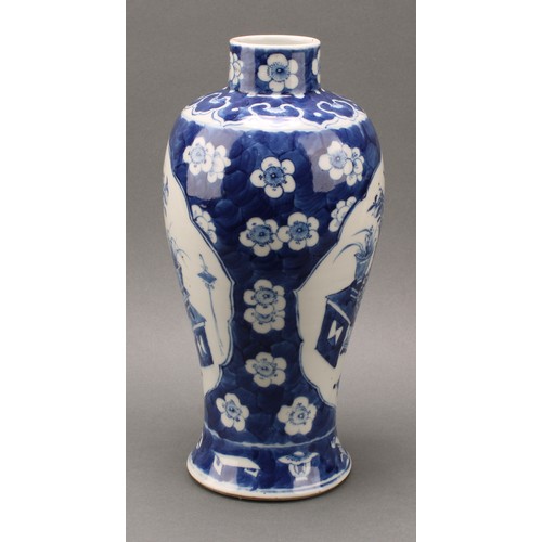 1385 - A Chinese baluster vase, painted in tones of underglaze blue with tables set with censers, planters ... 