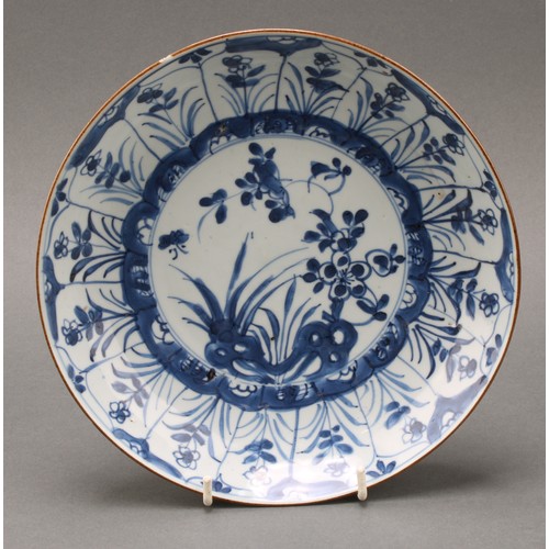 1425 - An early 18th century Chinese circular dish, painted in tones of underglaze blue with flowers and ro... 