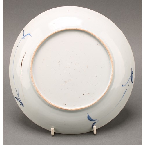 1425 - An early 18th century Chinese circular dish, painted in tones of underglaze blue with flowers and ro... 