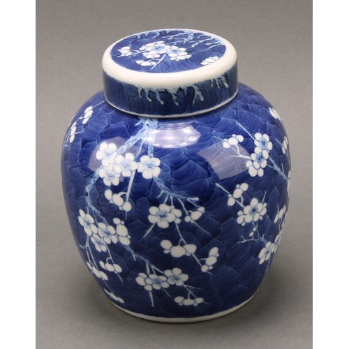 1404 - A Chinese ovoid ginger jar and cover, painted in tones of underglaze blue with prunus on a ground of... 