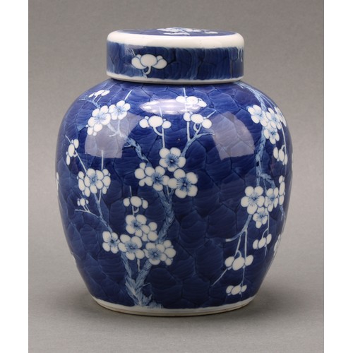 1404 - A Chinese ovoid ginger jar and cover, painted in tones of underglaze blue with prunus on a ground of... 