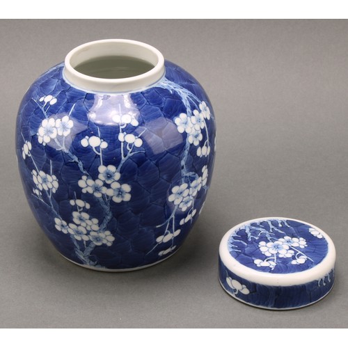 1404 - A Chinese ovoid ginger jar and cover, painted in tones of underglaze blue with prunus on a ground of... 