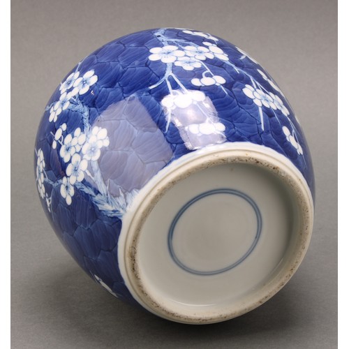 1404 - A Chinese ovoid ginger jar and cover, painted in tones of underglaze blue with prunus on a ground of... 