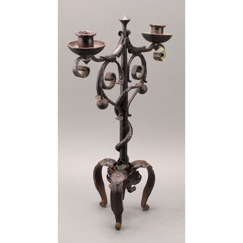 1849 - A pair of Arts and Crafts wrought iron two-light candelabra, the each pillar entwined with a serpent... 