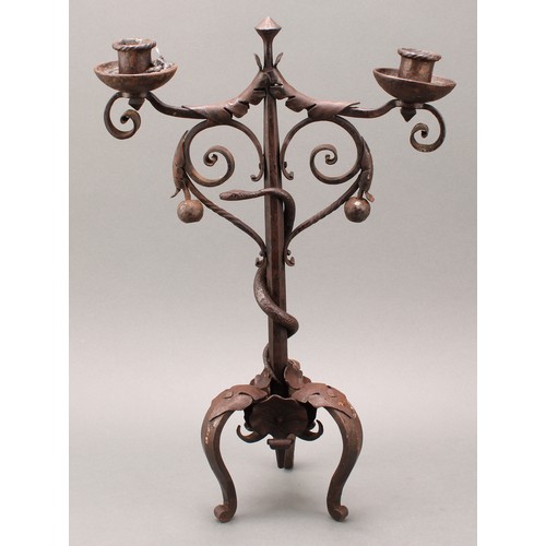 1849 - A pair of Arts and Crafts wrought iron two-light candelabra, the each pillar entwined with a serpent... 