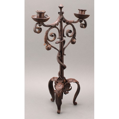 1849 - A pair of Arts and Crafts wrought iron two-light candelabra, the each pillar entwined with a serpent... 