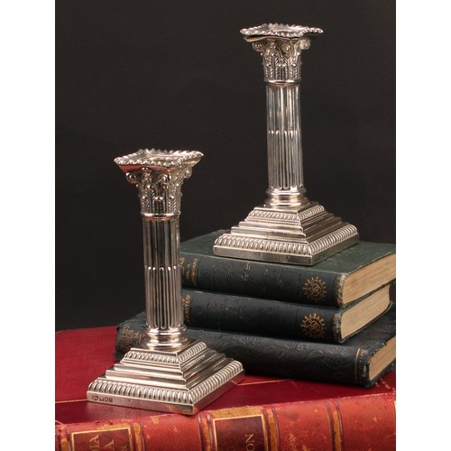 378 - A pair of Edwardian silver stop-fluted Corinthian column candlesticks, detachable nozzles, stepped b... 