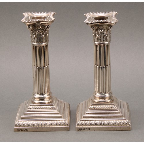 378 - A pair of Edwardian silver stop-fluted Corinthian column candlesticks, detachable nozzles, stepped b... 