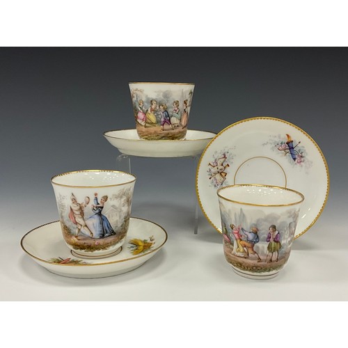 1238 - A trio of 19th century French tea cups and saucers, decorated with scenes of children play and danci... 