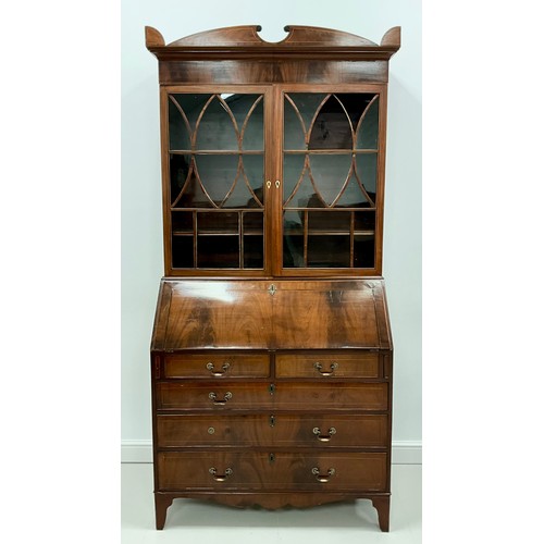 1911 - A Sheraton Revival mahogany bureau bookcase, shaped pediment above a pair of astral glazed doors enc... 