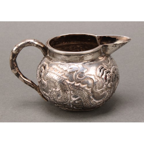 249 - A Chinese silver cream jug, chased with a dragon amongst scrolling clouds, faux, bamboo handle, 10cm... 