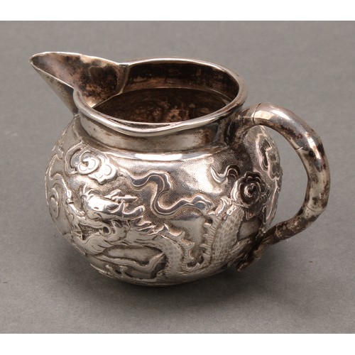 249 - A Chinese silver cream jug, chased with a dragon amongst scrolling clouds, faux, bamboo handle, 10cm... 