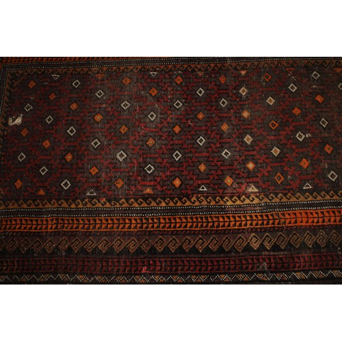 2063 - An Afghan Baluch woollen rug or carpet, 182cm x 101cm