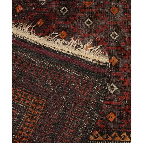 2063 - An Afghan Baluch woollen rug or carpet, 182cm x 101cm