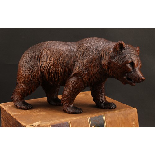 1552 - Treen - a 19th century Black Forest carving, of a brown bear in stride, 20cm high, 36cm long