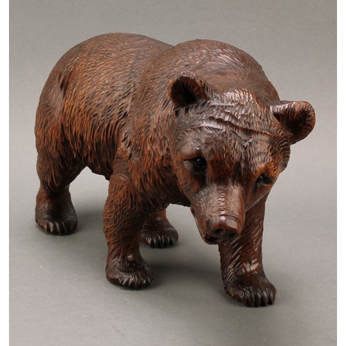 1552 - Treen - a 19th century Black Forest carving, of a brown bear in stride, 20cm high, 36cm long