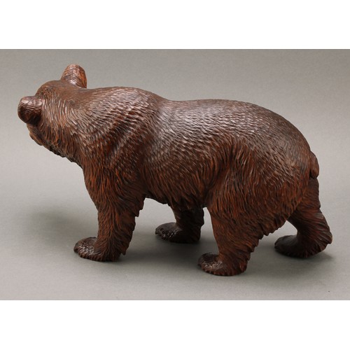 1552 - Treen - a 19th century Black Forest carving, of a brown bear in stride, 20cm high, 36cm long